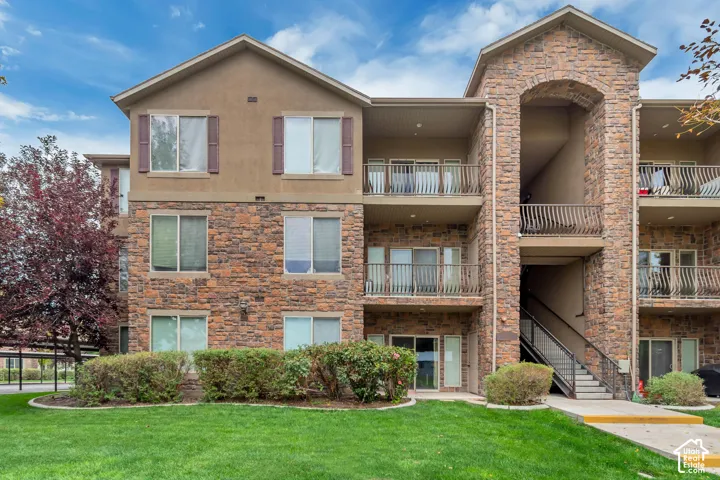 Multi-story building featuring stone veneer and stucco siding