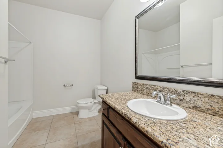 Vanity with a granite countertop, undermount sink, and chrome faucet