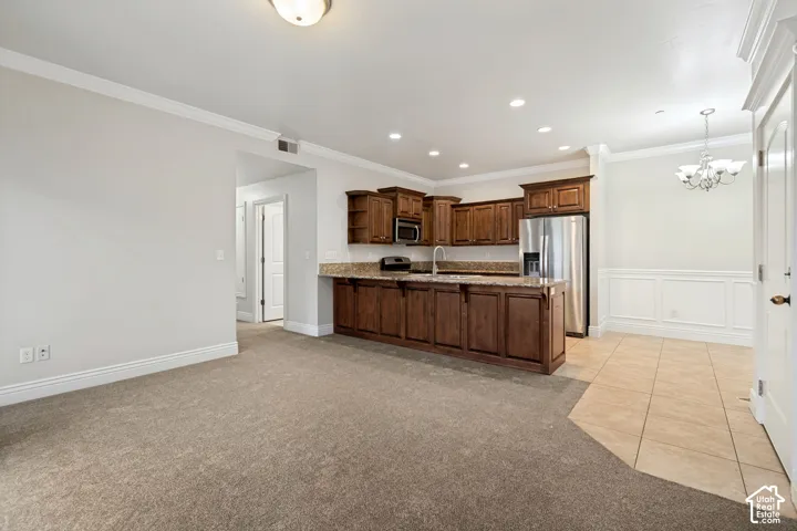 Kitchen with wood cabinetry, stainless steel appliances, and granite-style countertops