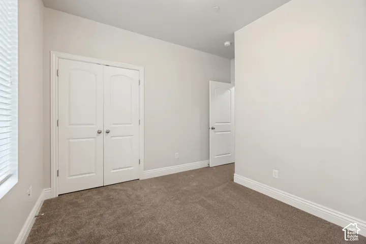 Neutral-toned walls, carpeted flooring, and white trim