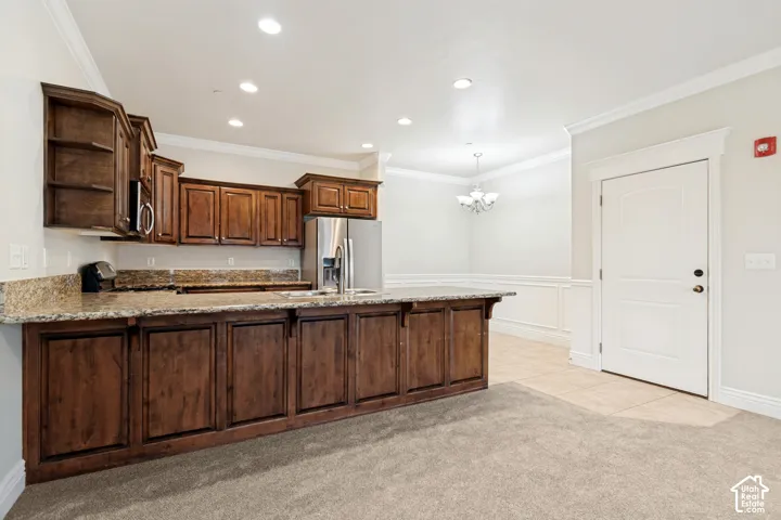 Kitchen island featuring a double-basin sink and stainless steel refrigerator