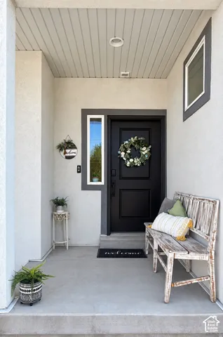 Recessed front entry featuring a solid black door, a vertical sidelight, and a square window