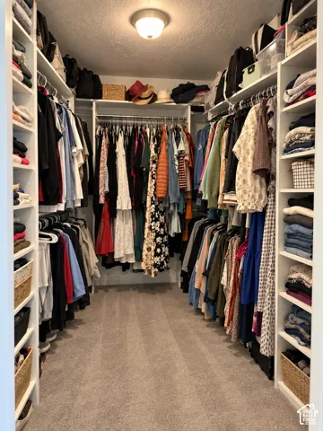 Walk-in closet featuring extensive built-in shelving, multiple hanging rods, and recessed ceiling lighting