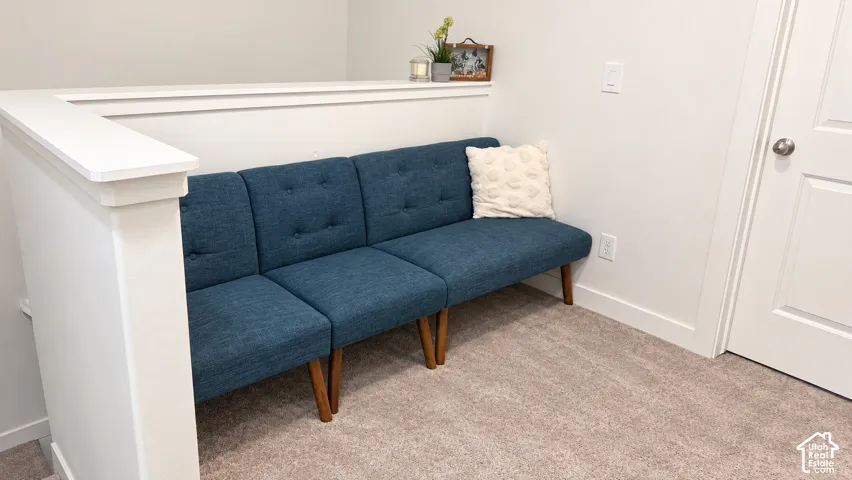 Carpeted flooring with white trim, a white interior door, and white painted walls