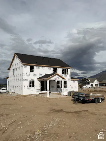 New construction, two-story residence featuring a gabled roof, covered porch, and mountain backdrop