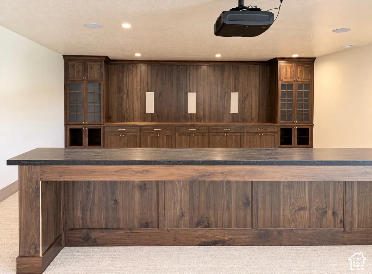Custom wood-finish cabinetry with glass-front display cabinets, built-in shelving, and drawers