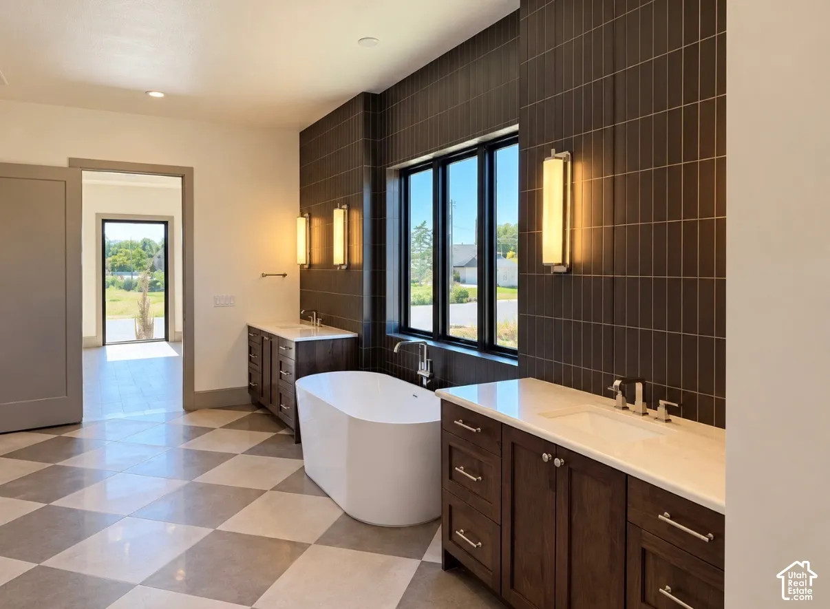 Spacious bathroom featuring a freestanding tub, dual vanity with undermount sinks, and a dark vertical tile accent wall