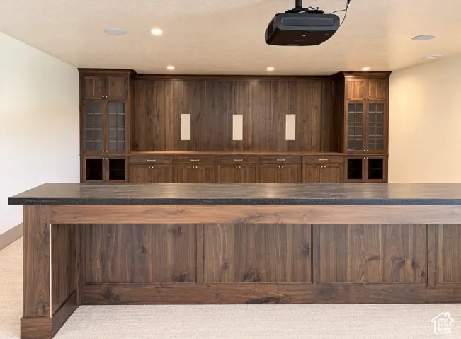 Custom wood-finish cabinetry with glass-front display cabinets, built-in shelving, and drawers