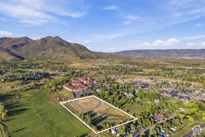 Expansive undeveloped land parcel with surrounding residential areas and distant mountains