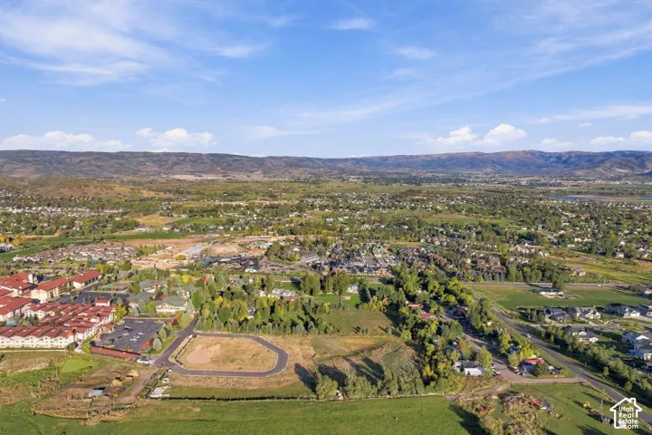 Expansive land parcel with surrounding residential areas and distant mountainous terrain