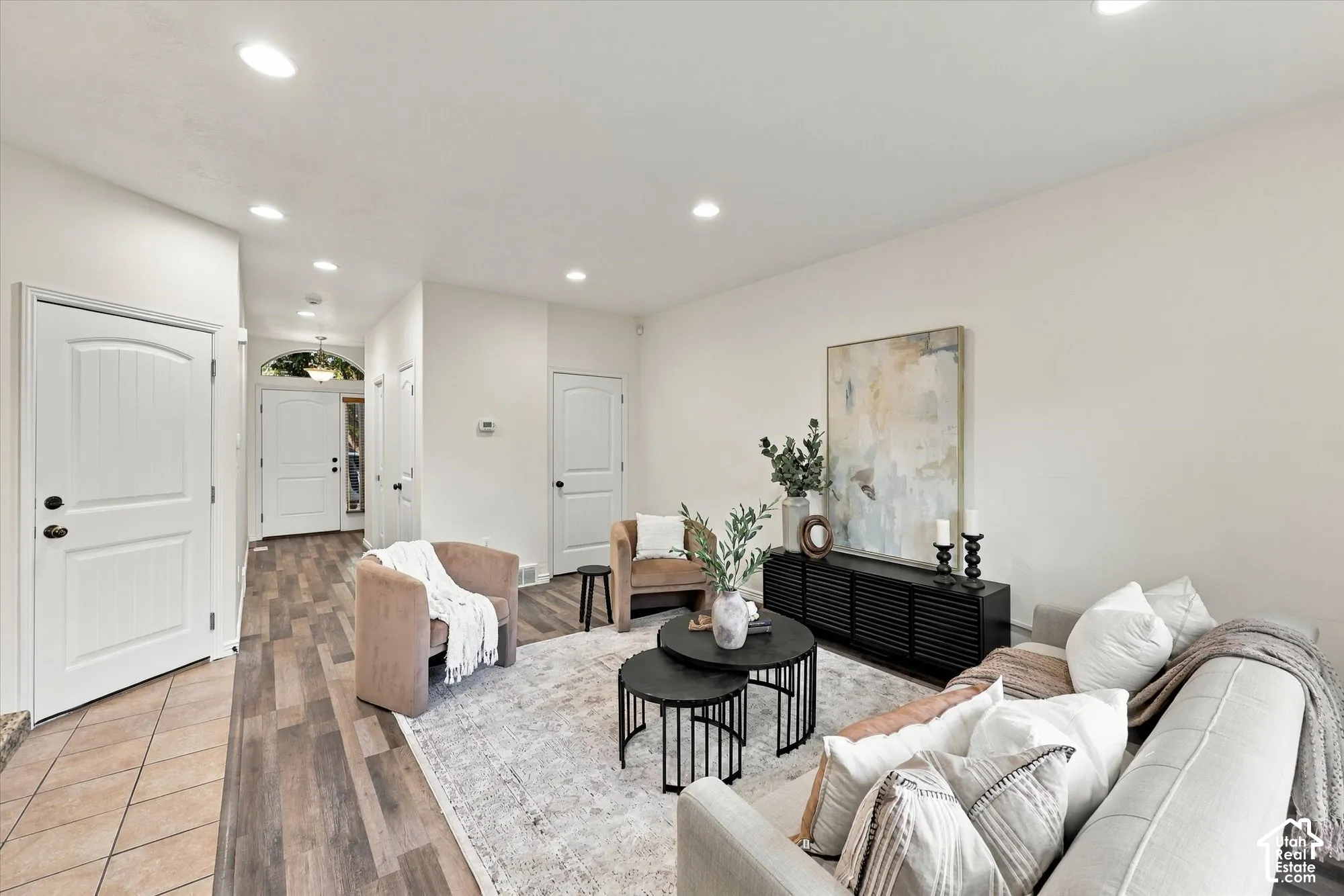Spacious living area featuring recessed lighting, LVP flooring. Hallway to the front door.