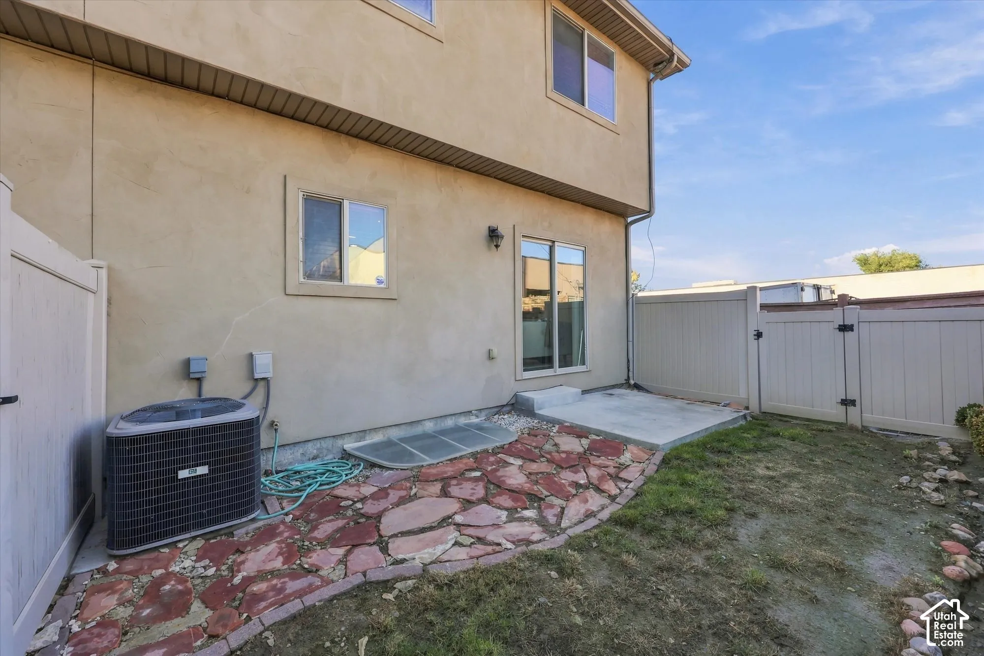 Fenced backyard, private outdoor space featuring a concrete patio and stone pavers