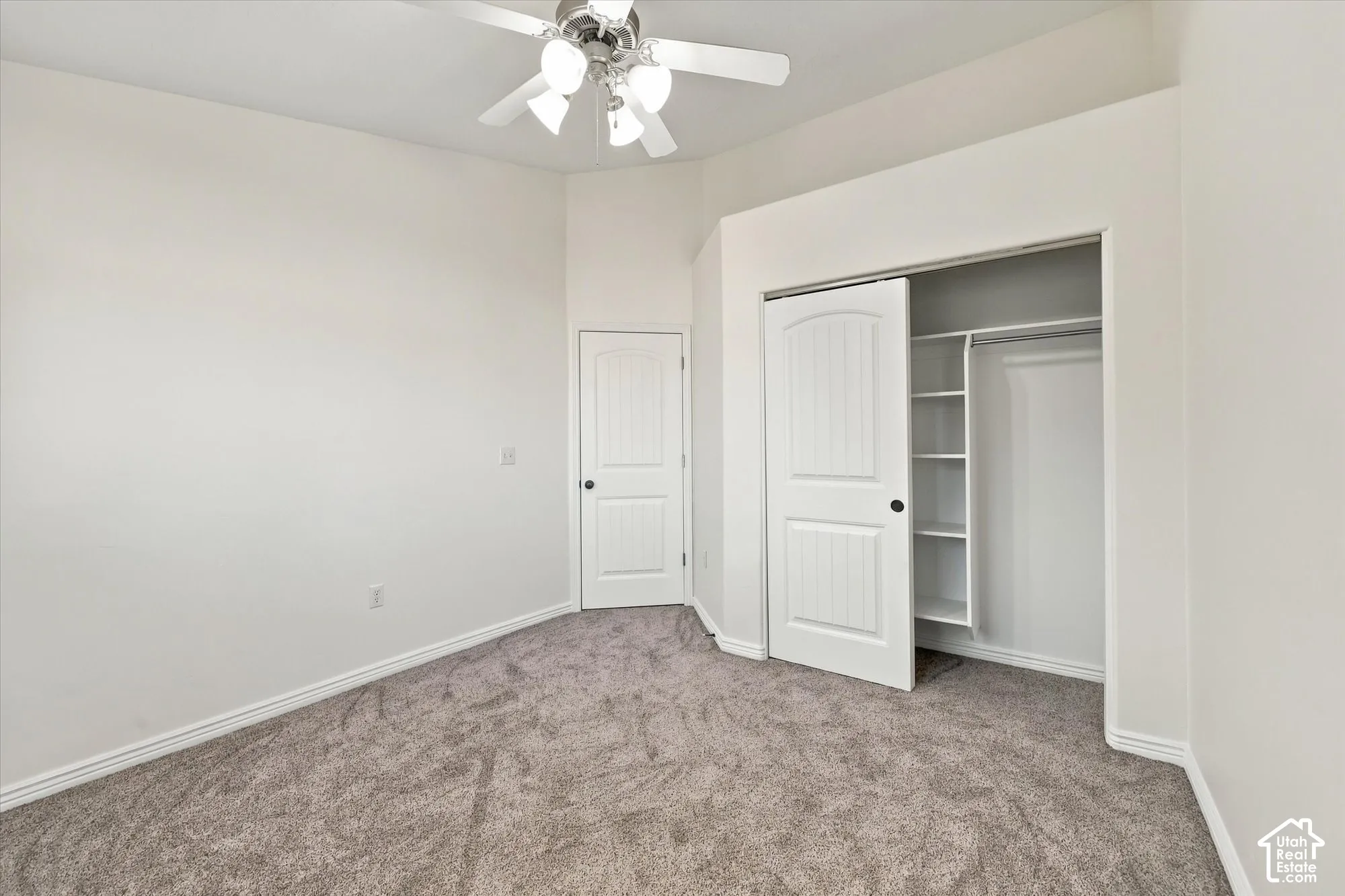 Bedroom with new paint and new carpet, a ceiling fan, and a built-in closet