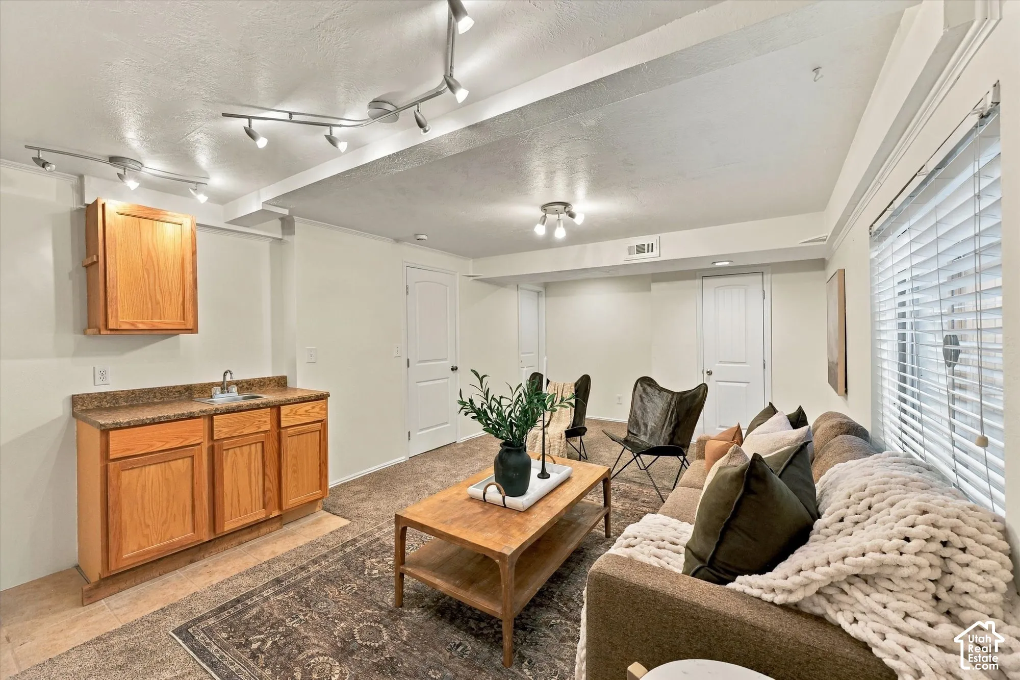 Wet bar with wood cabinetry and countertop, track lighting, recessed ceiling lighting, and window with blinds