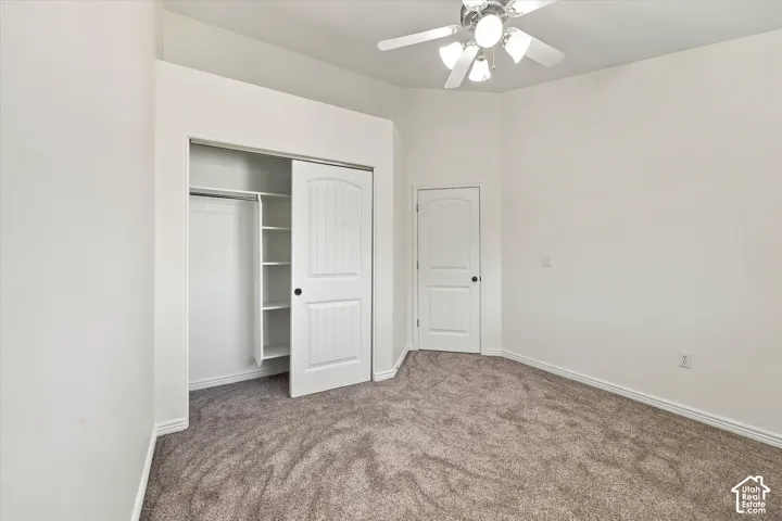 Bedroom with new paint and new carpet, a ceiling fan, and a built-in closet