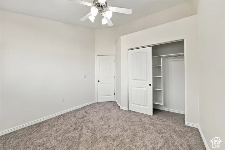 Bedroom with new paint and new carpet, a ceiling fan, and a built-in closet