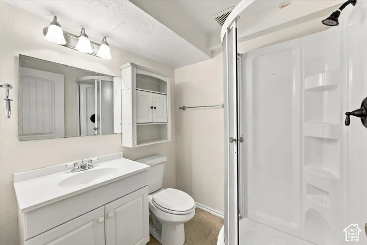 White vanity with integrated sink, rectangular mirror, and three-light fixture