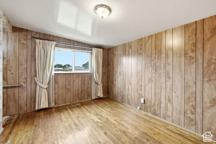 Wood-finish wall paneling, wood-finish flooring, and a flush-mount ceiling light fixture