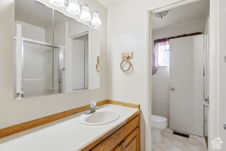 Bathroom featuring a built-in vanity with a laminate countertop, recessed sink, and overhead light fixture