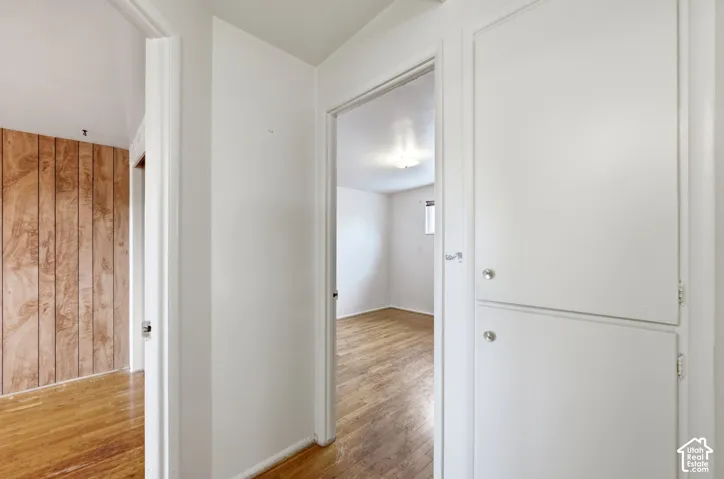 White painted walls, wood-finish flooring, and built-in white cabinetry