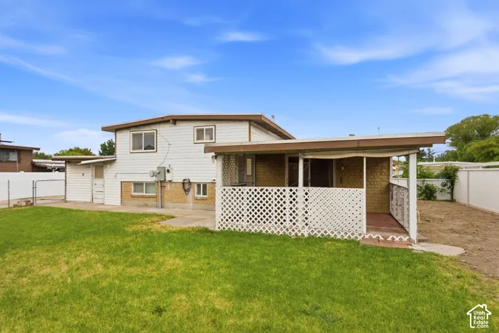 Expansive grassy yard with concrete patio and covered outdoor space