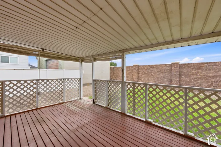 Covered outdoor patio with wood-finish decking and white lattice railings