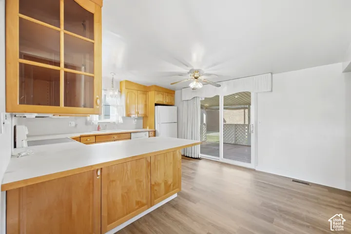 New LVP Flooring, light wood cabinetry, white countertops, glass-front upper cabinet, and sliding glass door