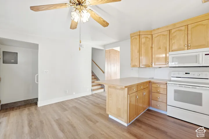 Kitchen featuring wood-finish cabinetry, white appliances, a ceiling fan, and wood-finish flooring