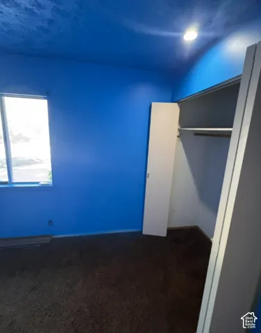 Room featuring a window, recessed lighting, and a built-in closet with shelving and a hanging rod