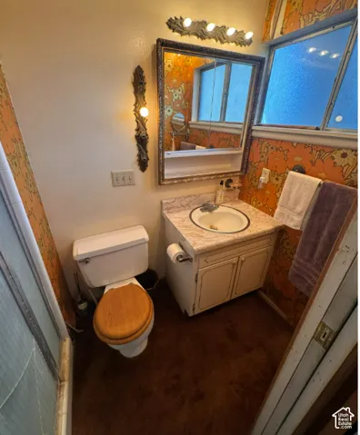 Vanity with an integrated sink and base cabinetry, complemented by a framed mirror and overhead lighting