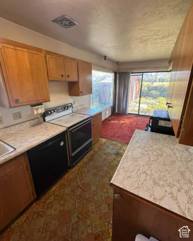 Kitchen featuring wood cabinetry, integrated sink, and an electric range