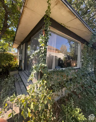 Expansive corner window, exterior siding, and a partial outdoor walkway
