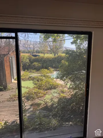 Sliding glass door with black frame, offering access to an exterior wood deck