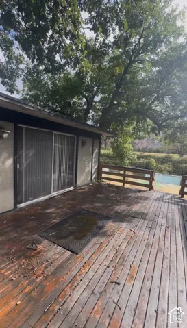 Exterior wood deck featuring a railing and an adjacent sliding glass door