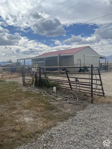 Metal outbuilding with a red metal roof and extended covered space
