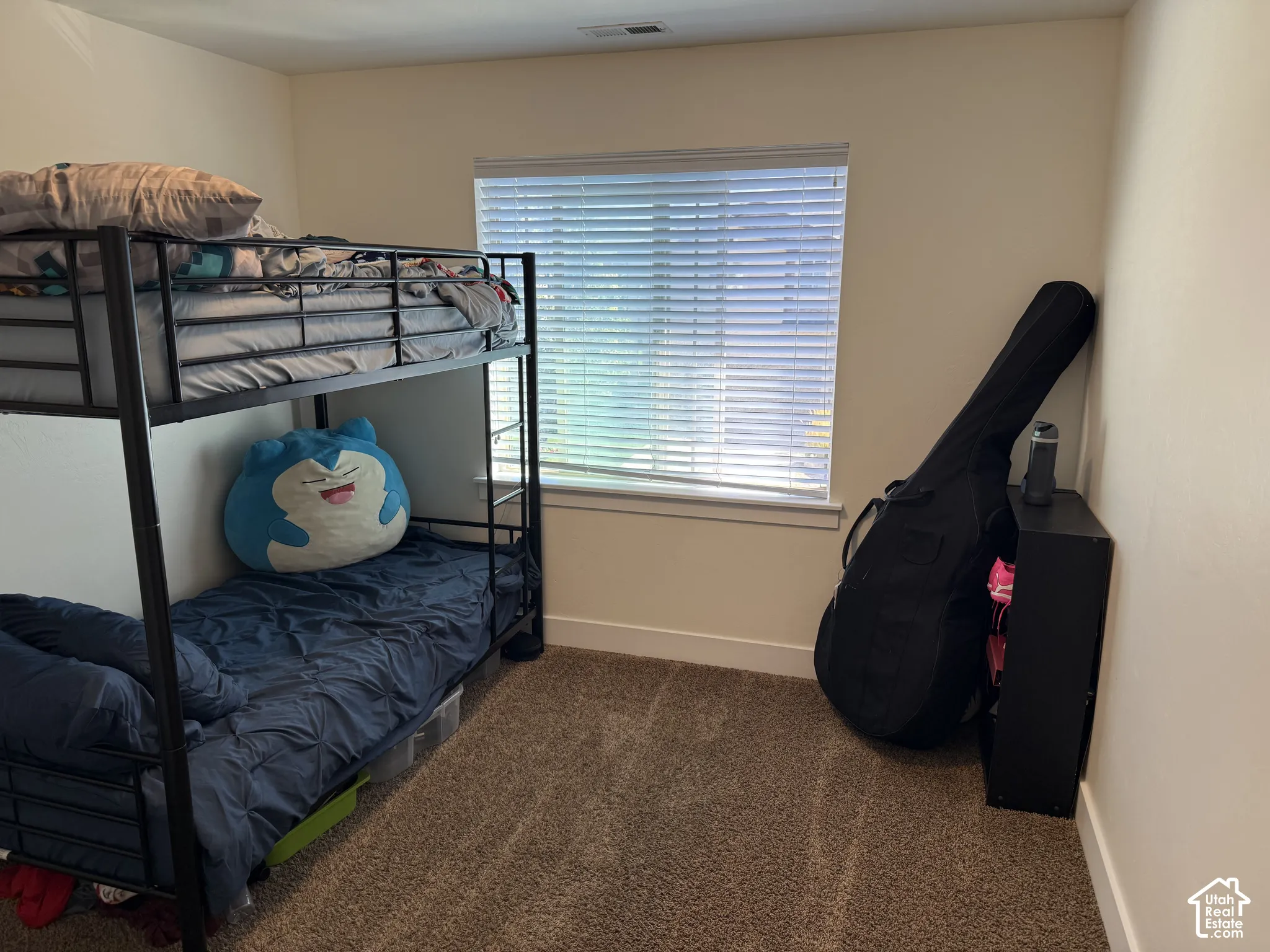 Carpeted flooring, neutral wall color, and a window with horizontal blinds