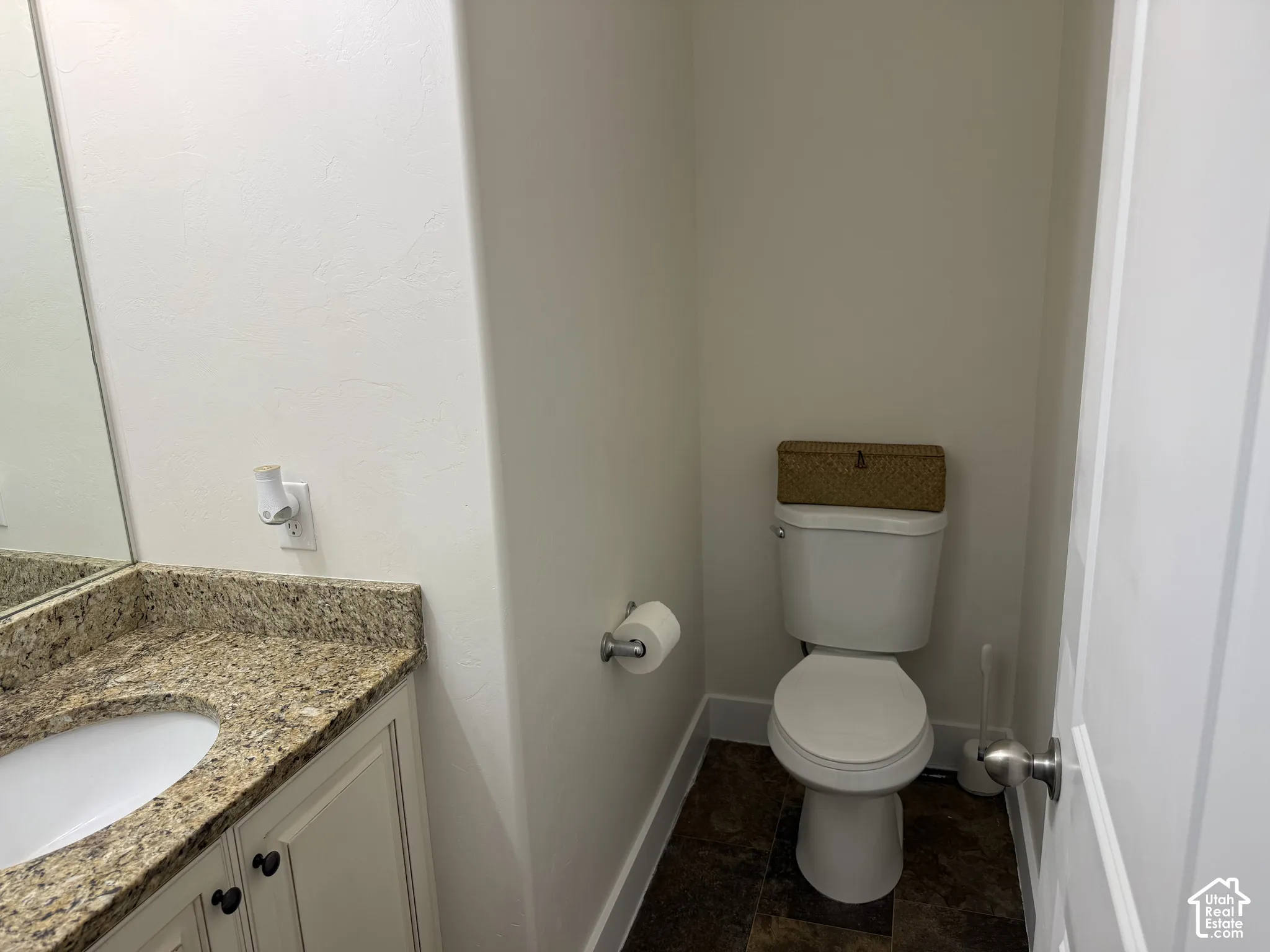 Vanity with a granite-style countertop, undermount sink, and cream-finished cabinetry