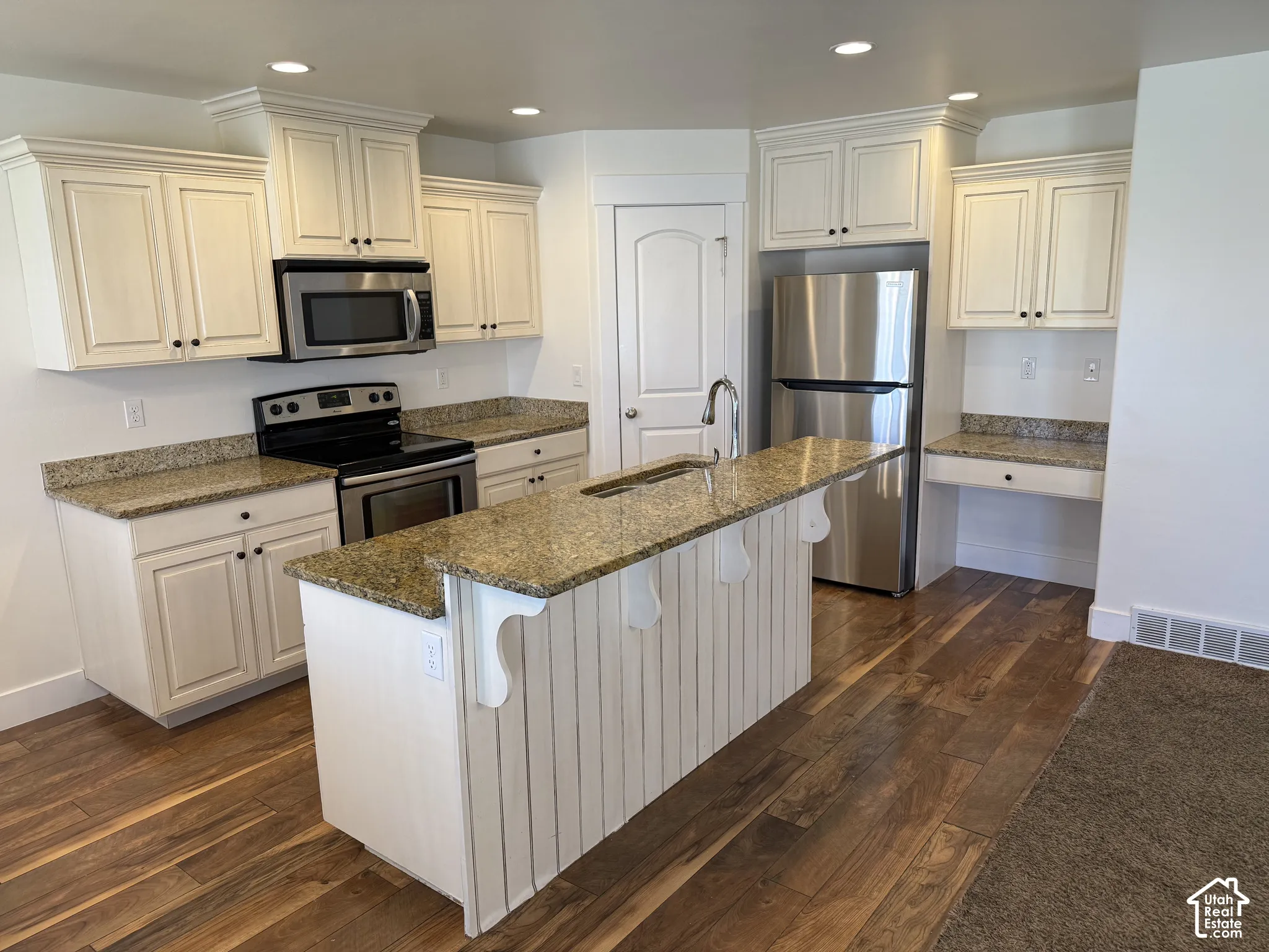 Kitchen featuring wood-finish flooring, recessed lighting, and white cabinetry
