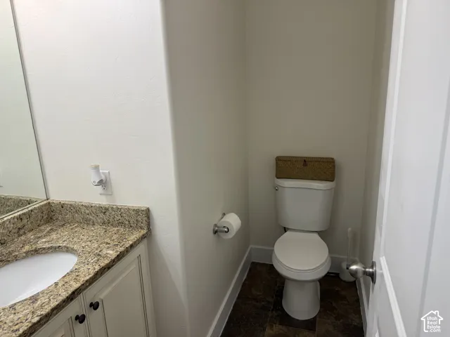 Vanity with a granite-style countertop, undermount sink, and cream-finished cabinetry