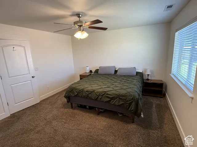Neutral wall finishes, textured carpeting, and a ceiling fan with integrated lighting