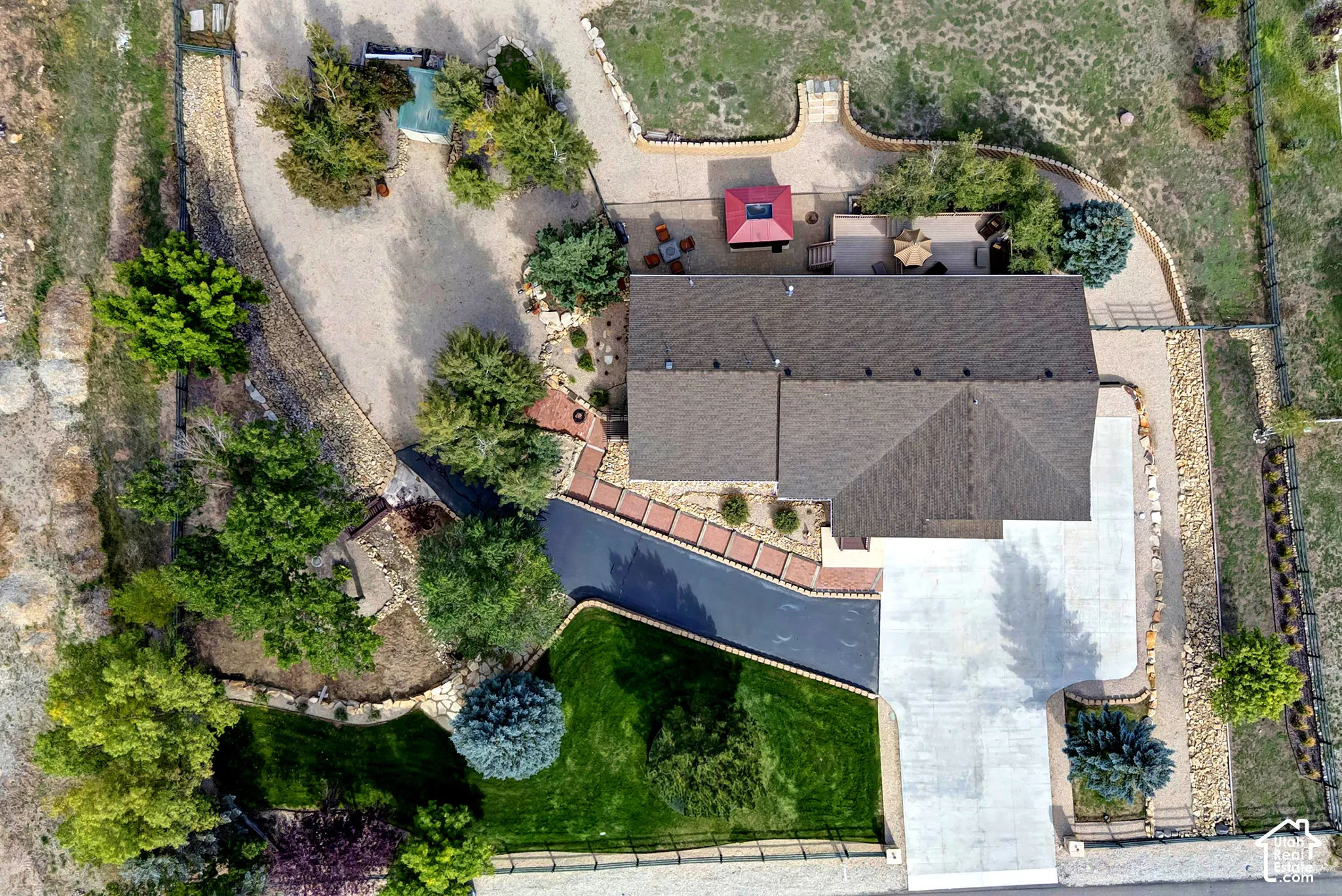 Expansive property featuring a large concrete driveway, paved asphalt drive, and a gravel pathway