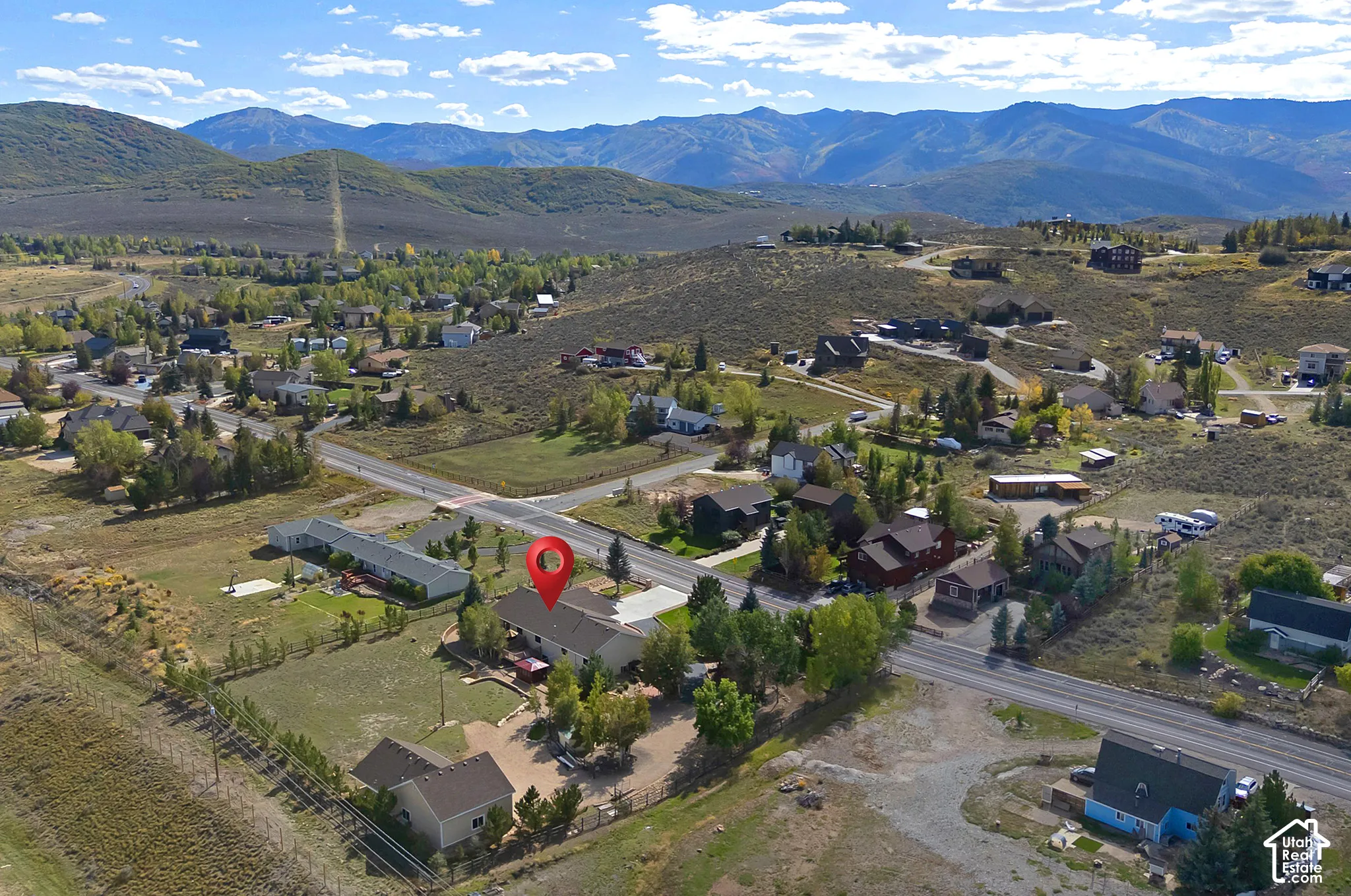 Expansive mountain scenery surrounding a residential area, featuring a paved road network and scattered homes