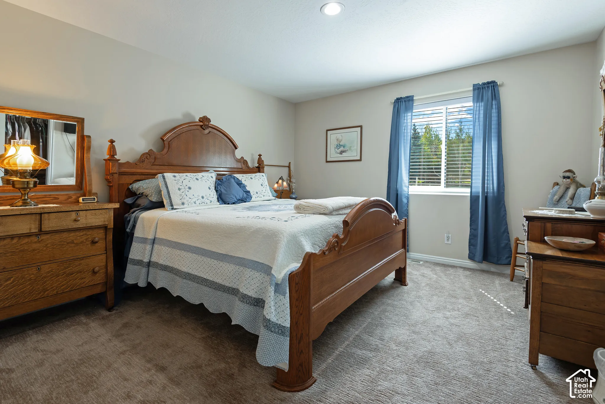 Recessed ceiling lighting, a window with horizontal blinds, and neutral-toned carpet flooring