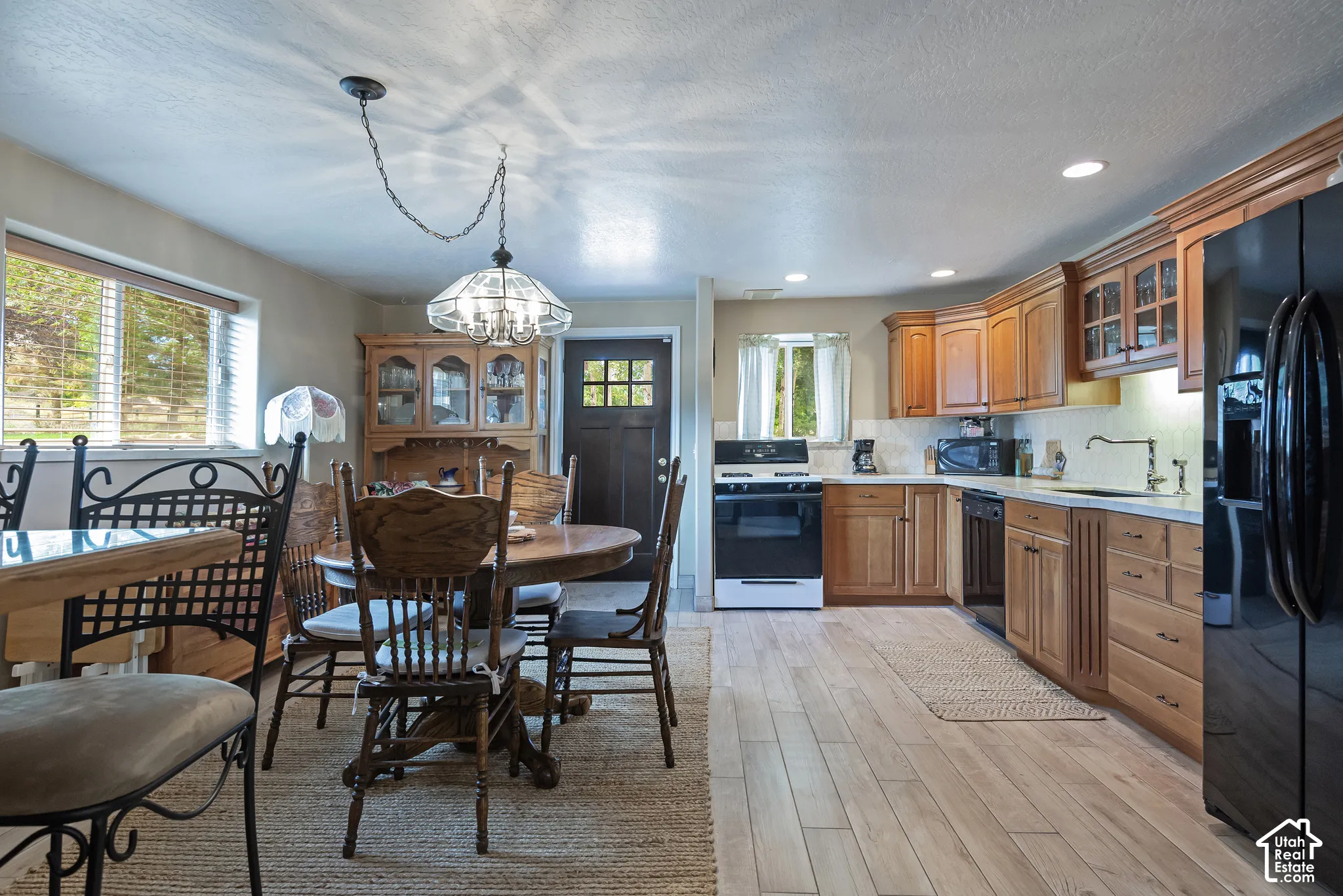 Kitchen featuring wood-finish flooring, wood cabinetry, recessed lighting, and a window above the sink