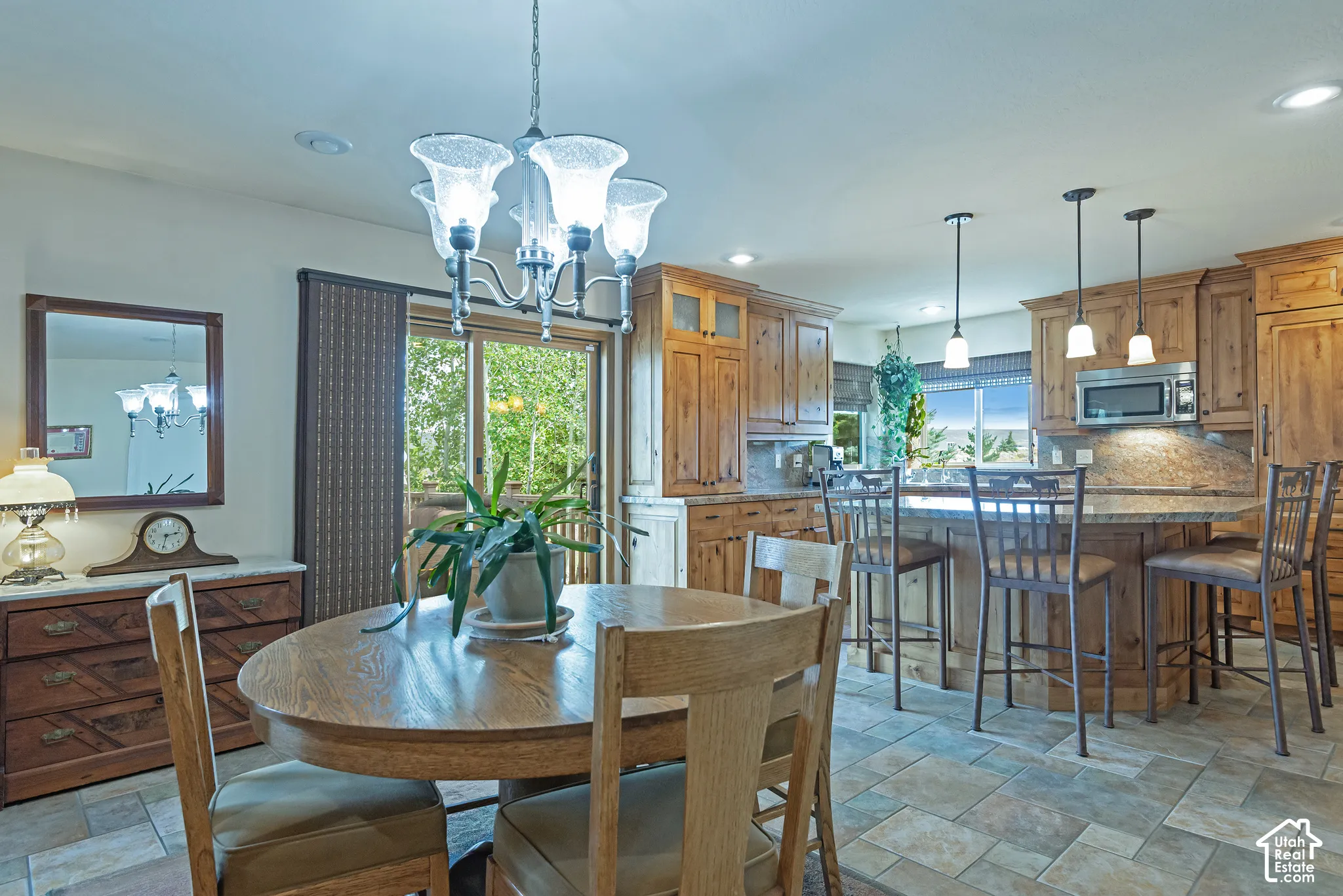 Recessed lighting, wood-finish cabinetry, tile flooring, built-in microwave, and pendant lighting