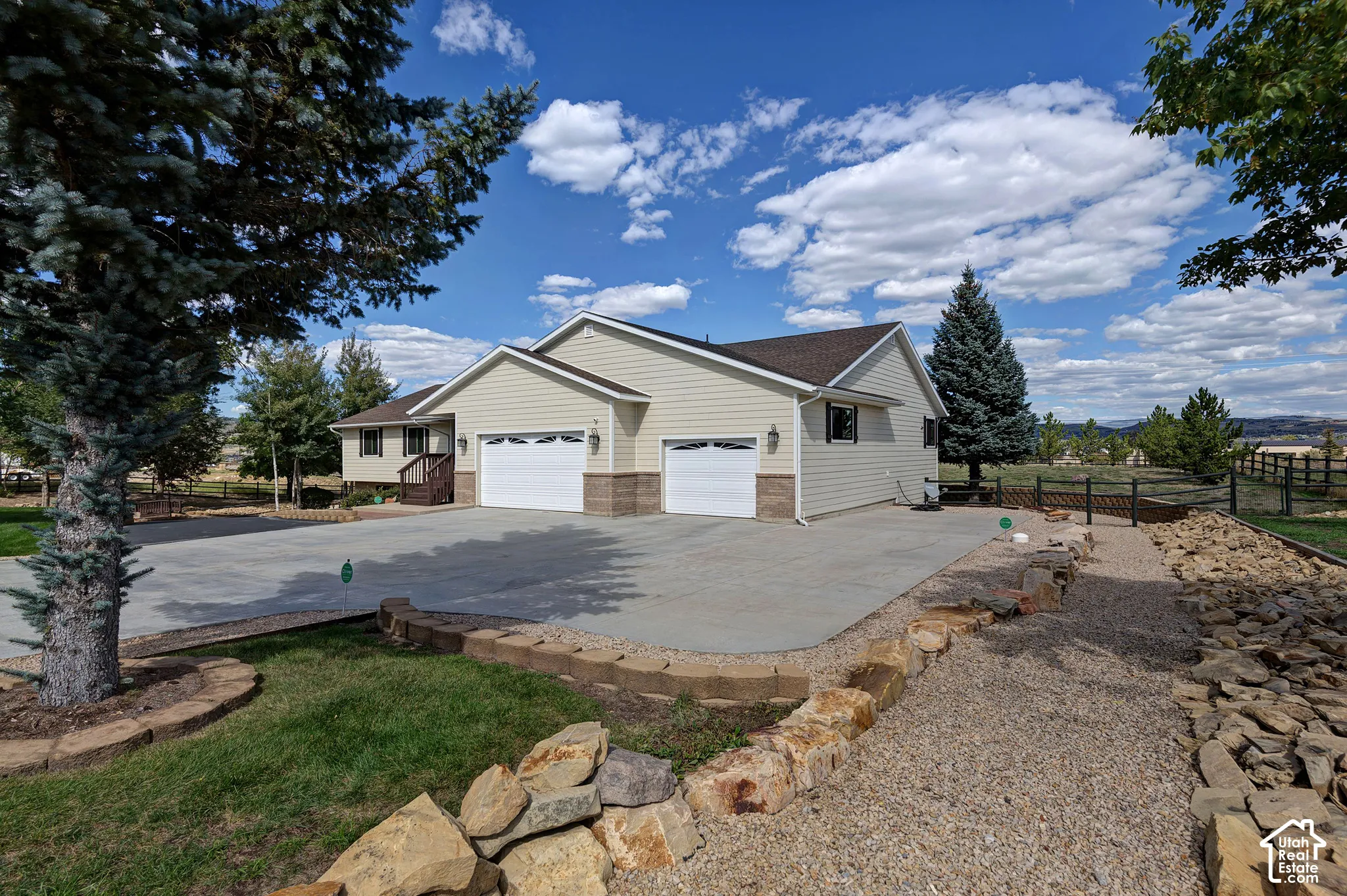 Exterior featuring light-colored siding, a stone facade, and a multi-car driveway