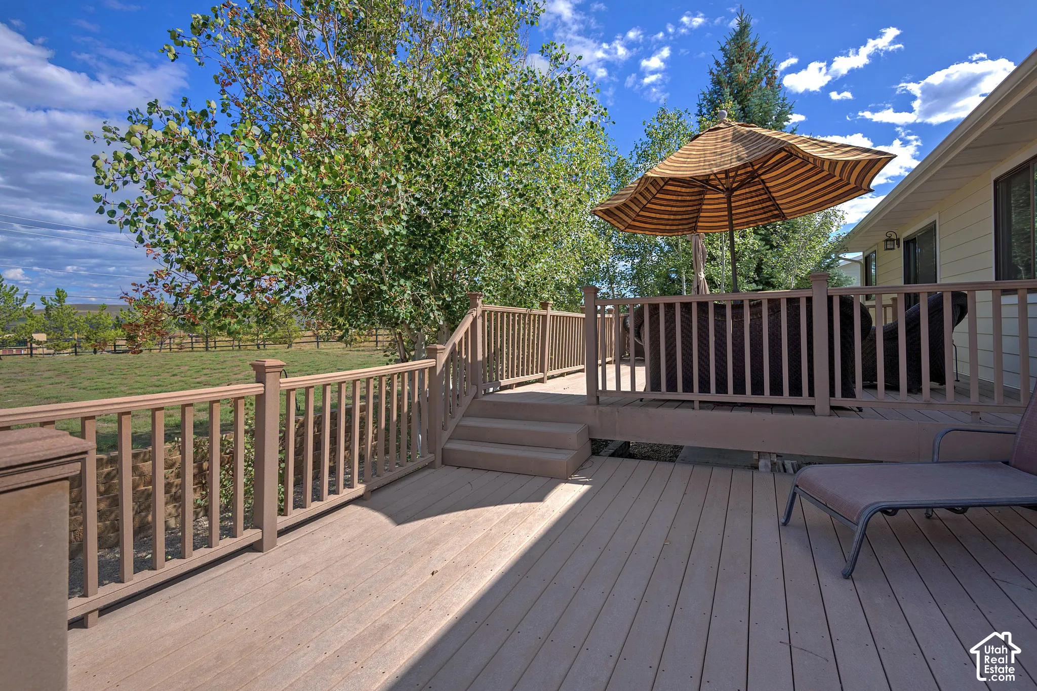 Expansive wood-finish deck with integrated steps, sturdy railing, and ample space