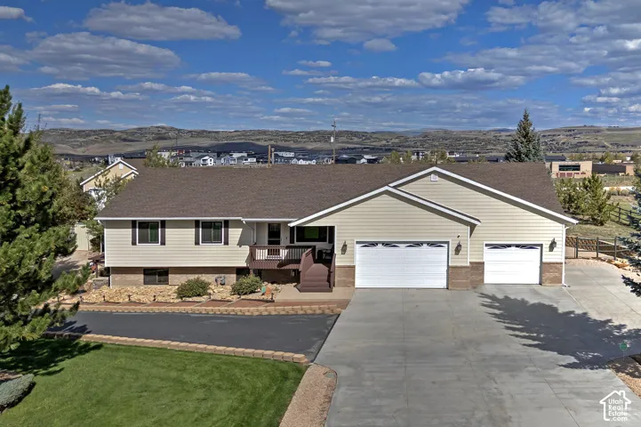 Front exterior featuring horizontal siding, a two-car garage, a separate single-car garage, and a concrete driveway
