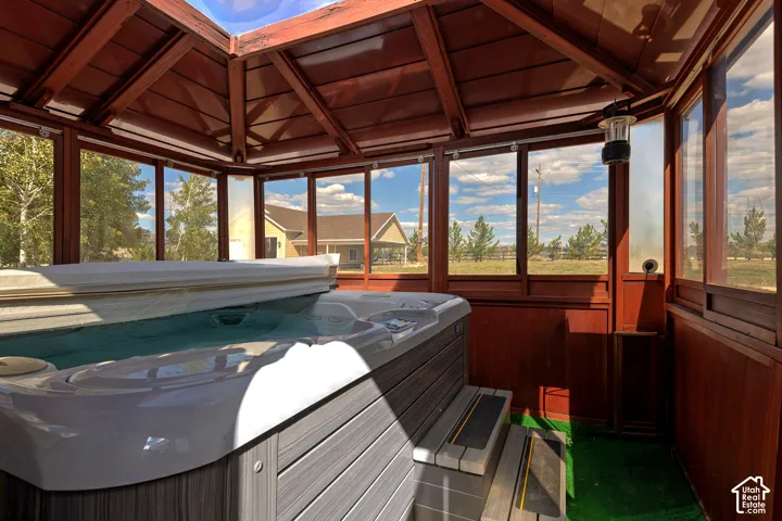 Enclosed hot tub structure featuring extensive wood paneling and a multi-paneled ceiling