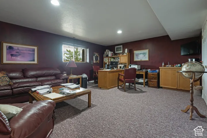 Recessed lighting, window with horizontal blinds, built-in cabinetry, wood-finish desk